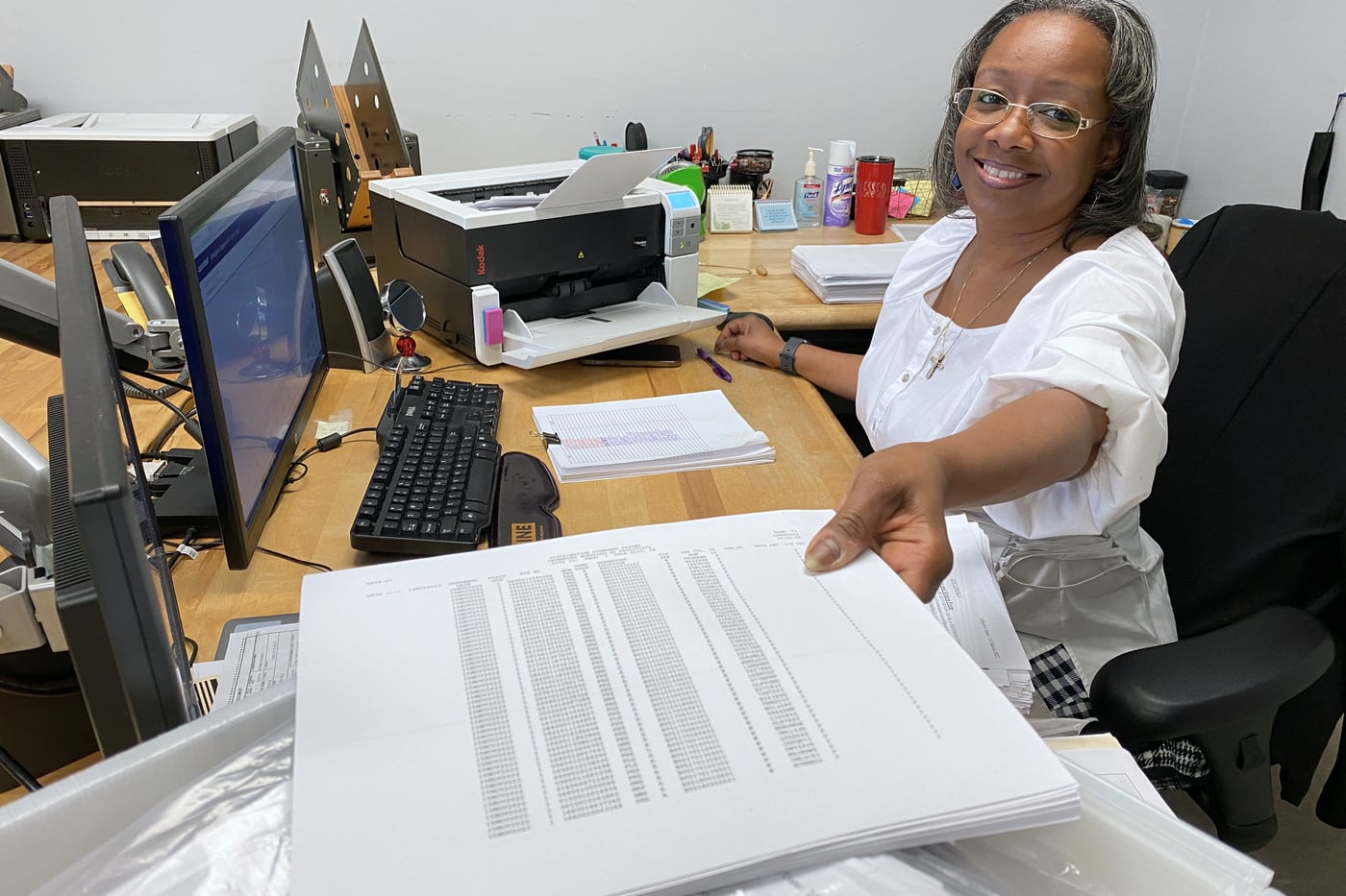 A federal civilian records professional scanning and reviewing documents at a government workstation